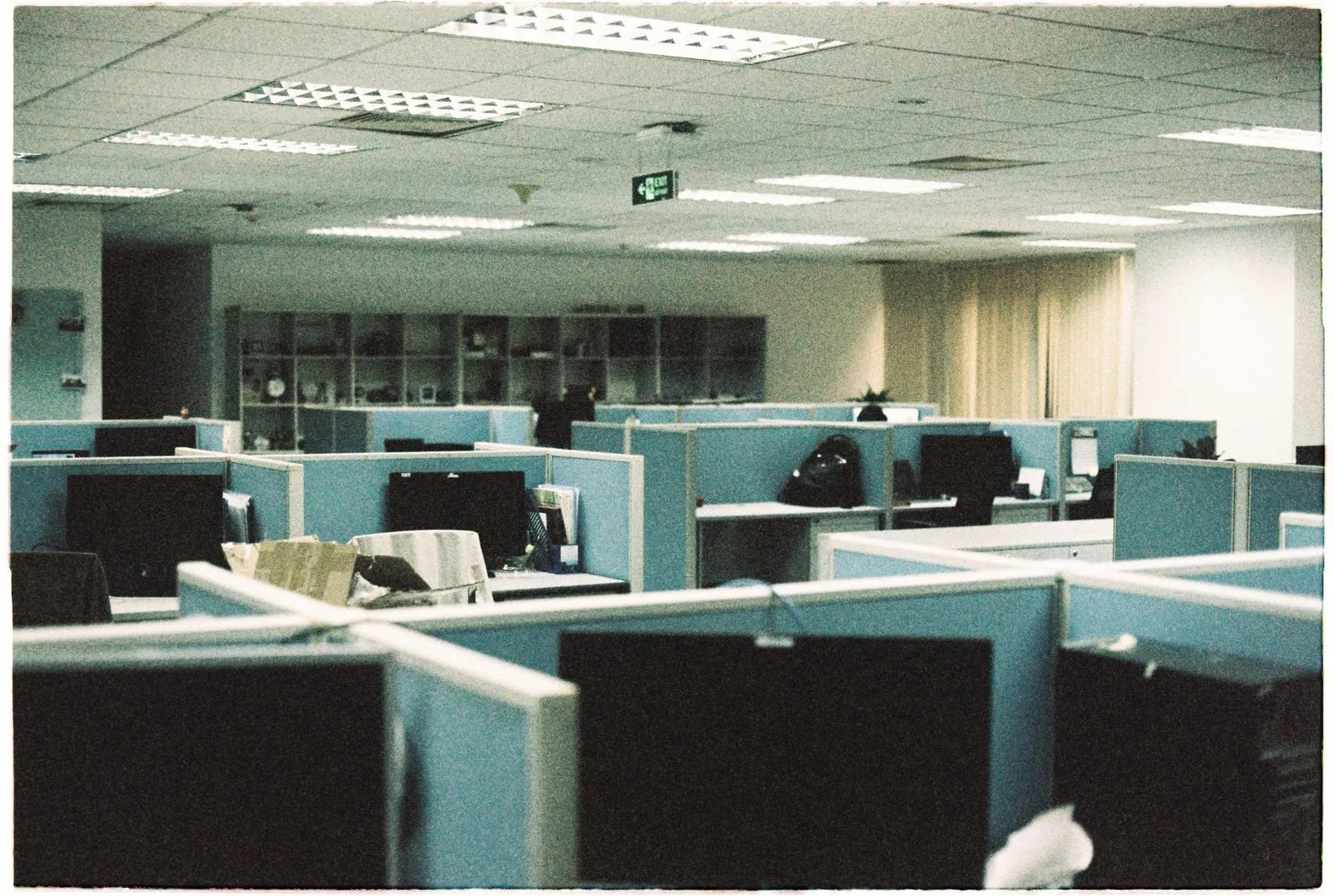 Empty office cubicles with switched-off monitors — the ghost job in physical form