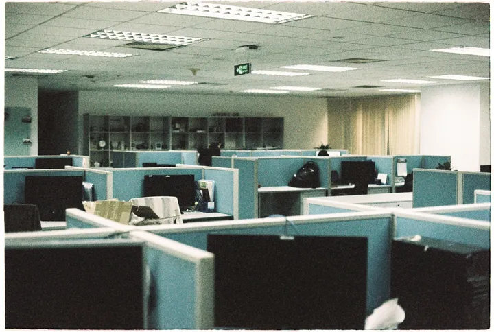 Empty office cubicles with switched-off monitors