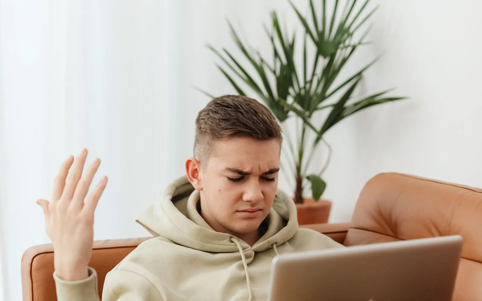 Frustrated applicant on a sofa with a laptop after more application silence
