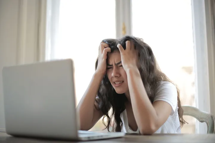 Frustrated job seeker at a laptop waiting for a reply