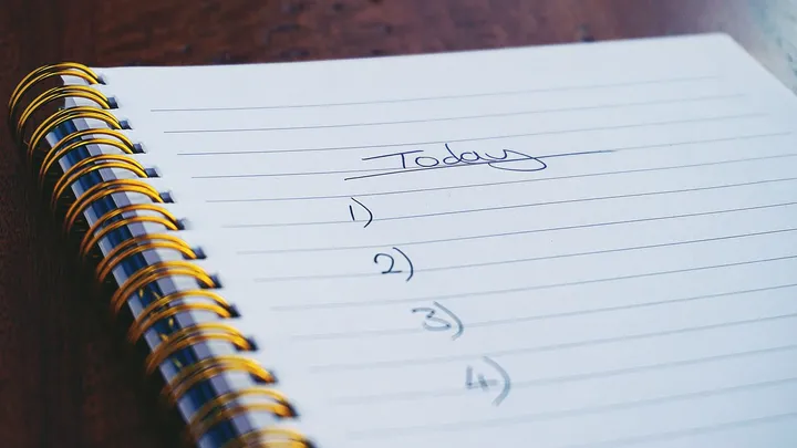 Handwritten numbered list in a spiral notebook