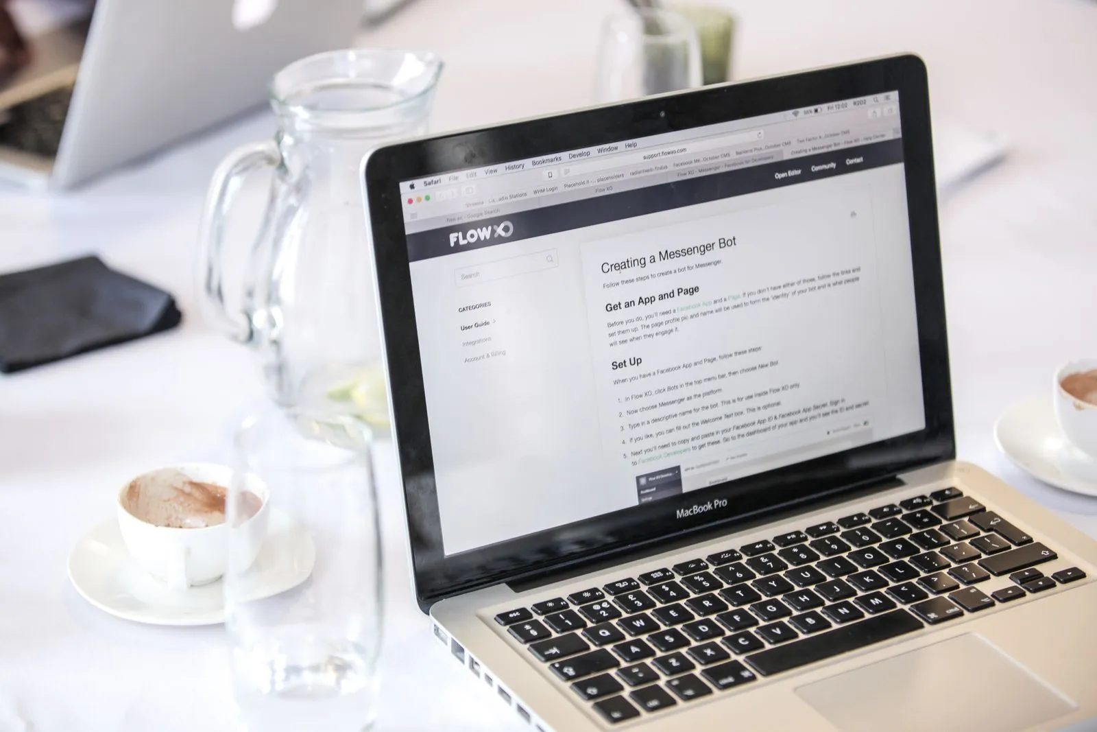 MacBook showing a webpage with coffee on a table — checking listings where they are published, not copied