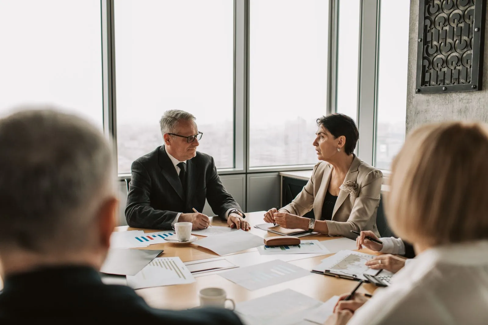 Managers discussing an open role in a meeting room — most hiring decisions happen before any listing goes live