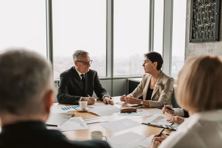 Managers discussing an open role in a bright office meeting room