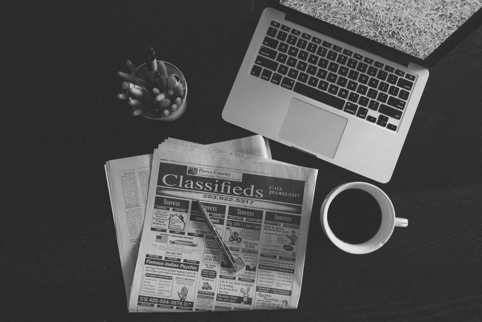 Newspaper, laptop and coffee on a desk — job boards are a discovery tool, not an application channel