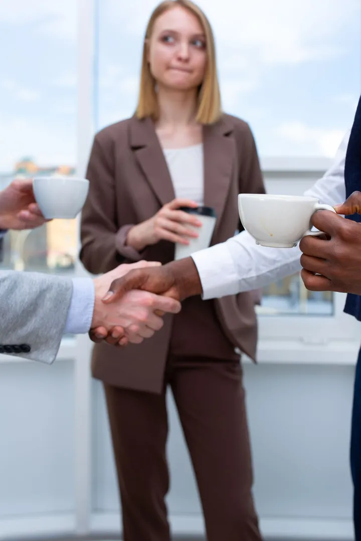 Professionals networking over coffee and shaking hands