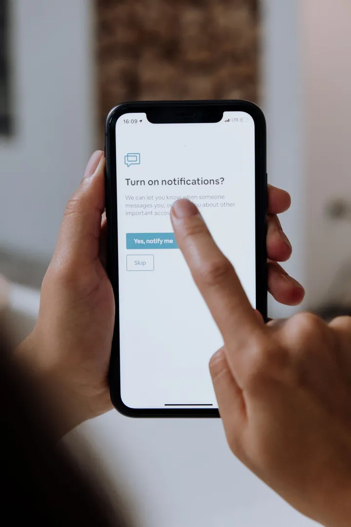 Hands setting up notifications on a smartphone
