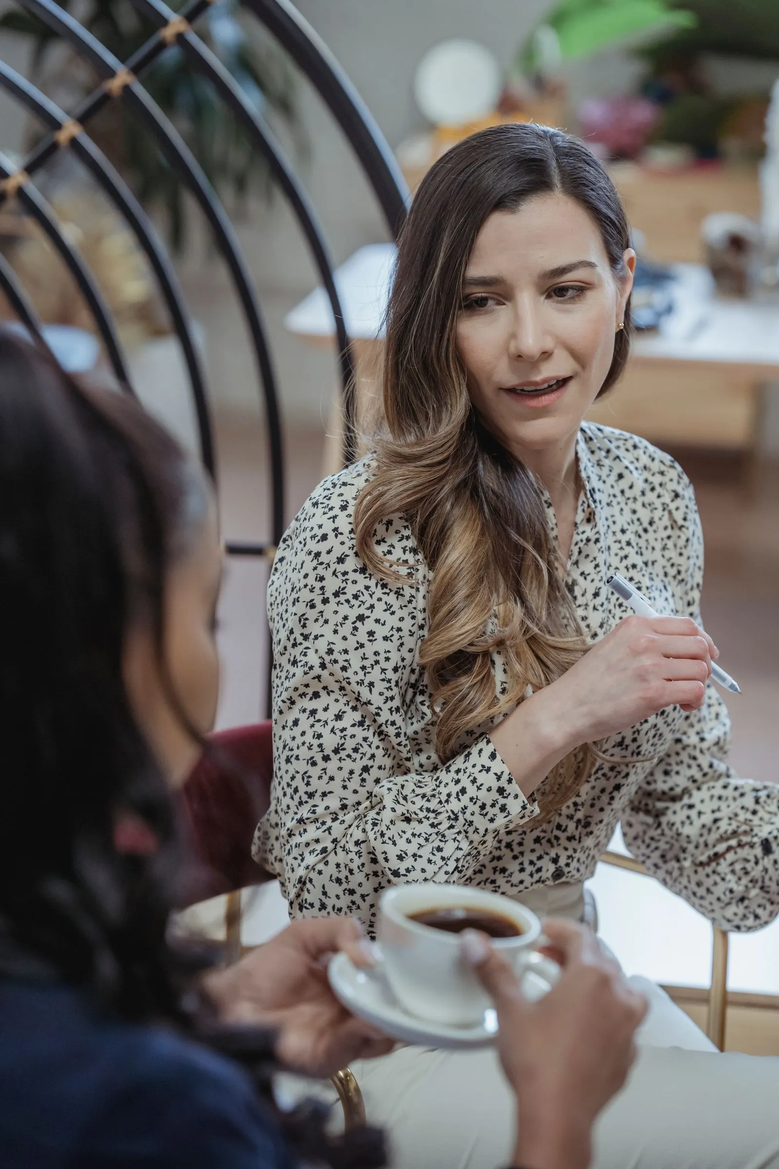 Two colleagues talking over coffee at work — specific conversations beat generic networking